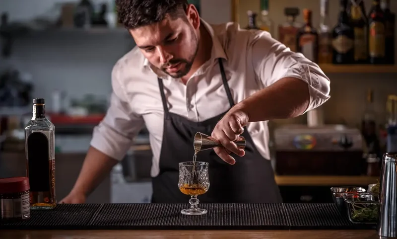 bartender pouring alcohol carefully