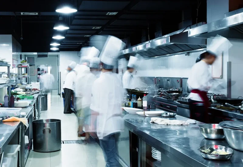 chefs moving quickly while cooking in large kitchen