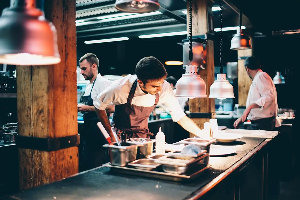 cook serving food on a plate in the restaurant kitchen