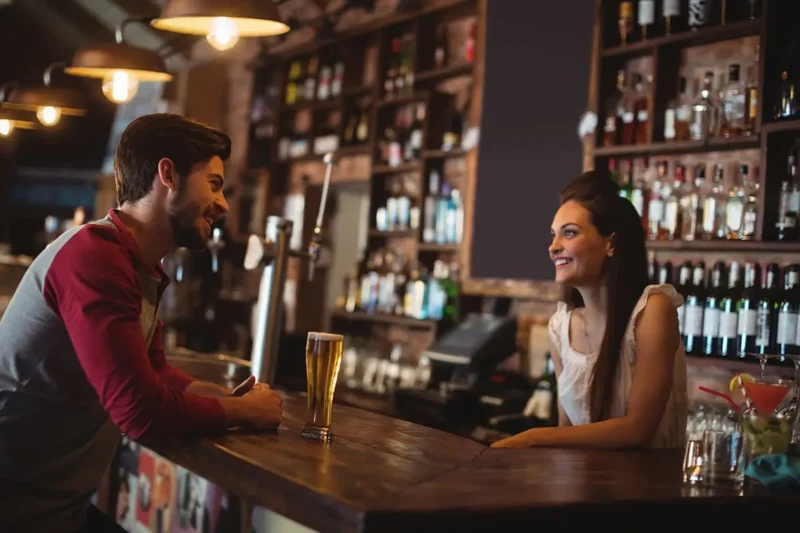 female bartender speaking with customer