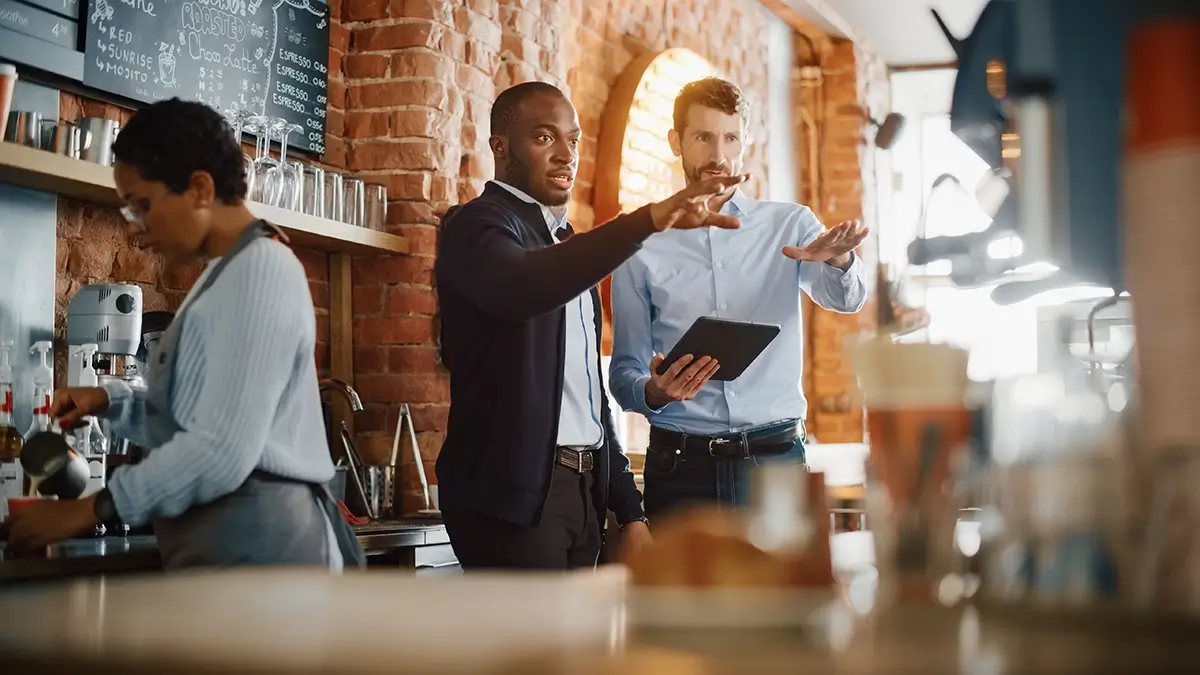 restaurant manager pointing to a table while talking to employee