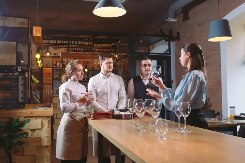 restaurant manager training new employees at the bar