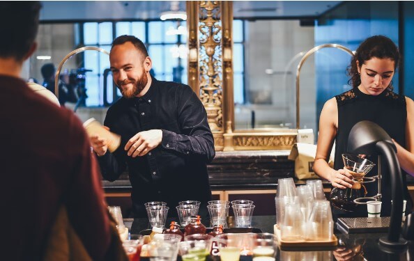 Two bartenders working behind a bar