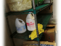 Chemicals being stored in the walk-in above lettuce.