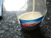 Sweetened condensed milk being stored in a Windex bottle and was being sprayed on snow cones for small children.